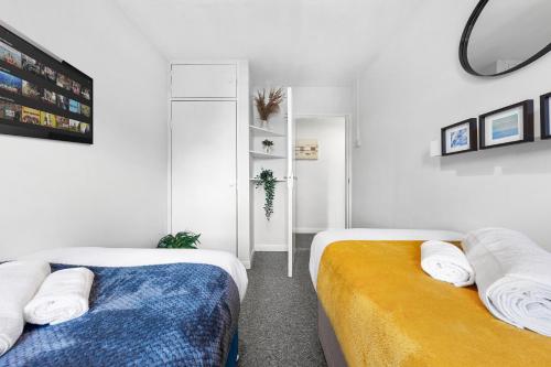 two beds in a room with white walls at South Stays 3 in London