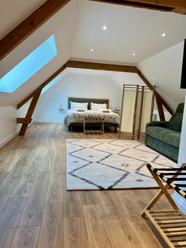 - une chambre mansardée avec un lit et un canapé dans l'établissement Gîte les pins - Maison cosy et calme à Ardres, à Ardres