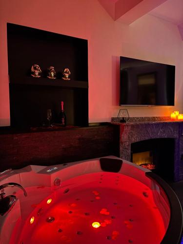 a red tub in a room with a fireplace at Love Room L'instanté - Suite "L'élégante" in Limoux