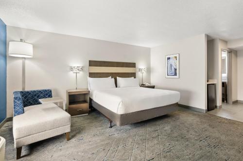 a hotel room with a bed and a chair at Holiday Inn Express Princeton/I-77 by IHG in Princeton