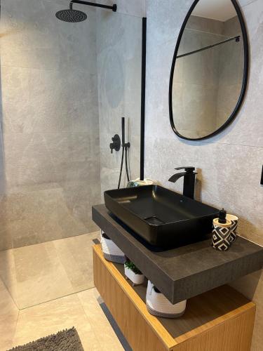 a bathroom with a black sink and a mirror at Villa Hana - San Pietro in Fushë-Draç