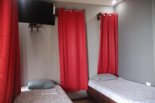 two red curtains in a room with two beds at Zona de Piratas 