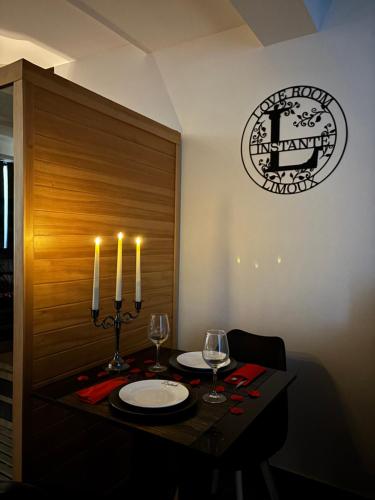 a dining room with a table with two glasses and candles at Love Room L'instanté - Suite "L'élégante" in Limoux