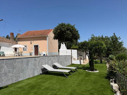 a garden with two benches and a retaining wall at Casas Bemposta in Monchique