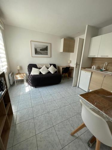 un salon avec un canapé noir et une cuisine dans l'établissement Studio 200m mer et promenade des anglais, à Nice