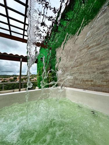 a bath tub filled with water next to a stone wall at Curiti Luxury House in Curití
