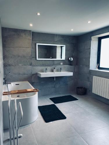 une salle de bain avec un lavabo et une baignoire dans l'établissement Gîte les pins - Maison cosy et calme à Ardres, à Ardres
