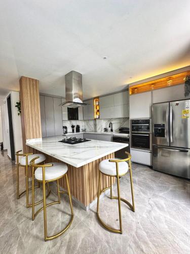 a kitchen with a counter with stools in it at Curiti Luxury House in Curití