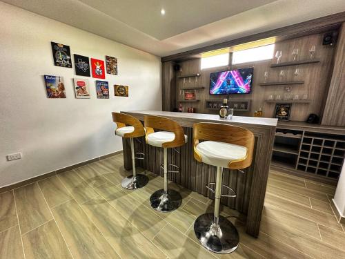 a bar with two stools and a television in a room at Curiti Luxury House in Curití