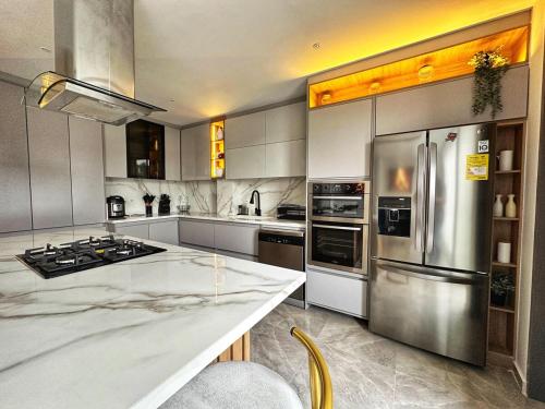 a large kitchen with stainless steel appliances at Curiti Luxury House in Curití