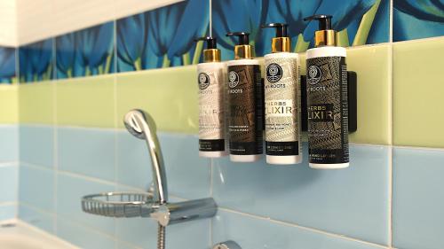 a row of four shampoo bottles on a shelf in a bathroom at villa strati in Nafplio