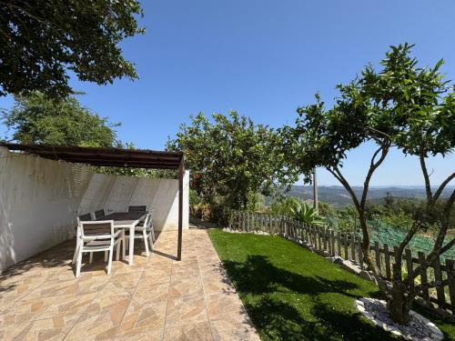 a patio with a table and chairs and a fence at Casas Bemposta in Monchique