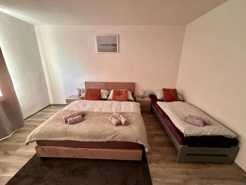 1 dormitorio con 2 camas con almohadas rosas en Apartmán u zajaca v Liptovskom Trnovci, en Liptovský Trnovec