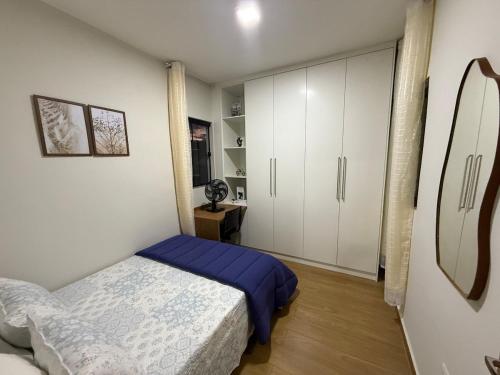 una camera da letto con un letto e armadi bianchi di Lindo apto prox shopping a São João del Rei