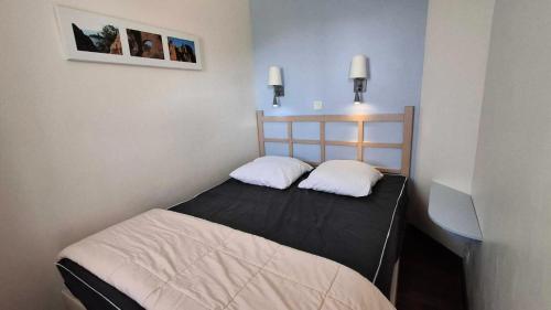 - 2 lits dans une chambre avec 2 photos sur le mur dans l'établissement Résidence le Village de Cap Esterel - maeva Home - Appartement 2 pièces 5 personnes - Sélection MAE-5754, à Saint-Raphaël