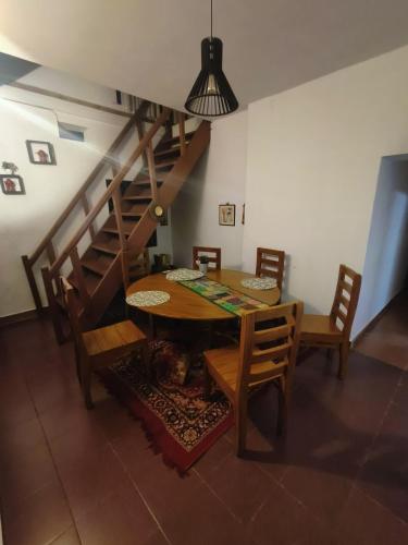 a dining room with a wooden table and stairs at Reevilla in Madikeri