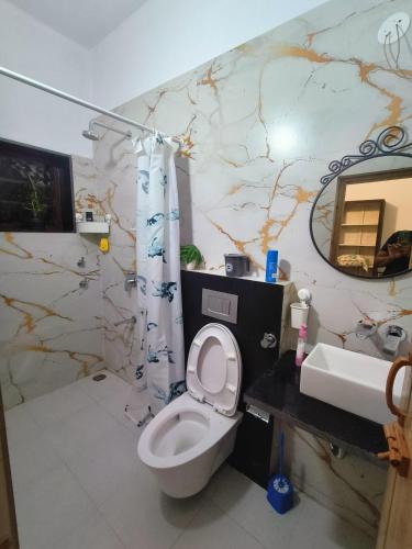 a bathroom with a toilet and a sink at Reevilla in Madikeri