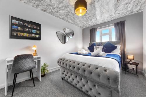 a bedroom with a bed and a chair and a window at South Stays 4 in London