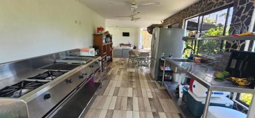 a kitchen with stainless steel appliances and a wooden floor at Casa Lapa Mar in Esterillos