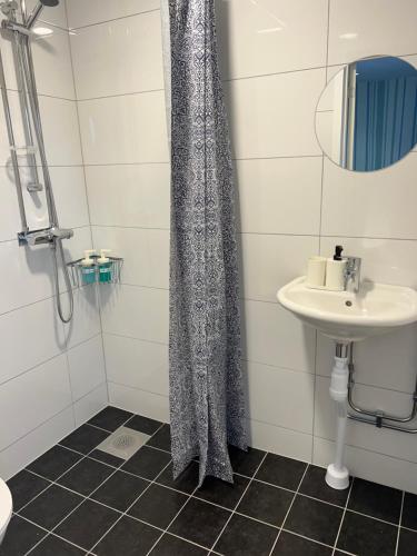 MunkforsにあるHotel Munkforsのシャワーカーテンと洗面台付きのバスルーム