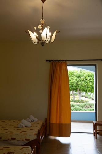 a bedroom with two beds and a chandelier and a window at Hotel Marilen in Alinda