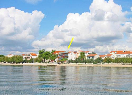 a yellow kite flying over a beach with houses at Apartments Aurelia in Vodice