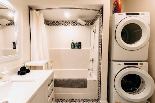 a bathroom with a washing machine next to a sink at Revy To Go - Unique 2-Bedroom Condo in Revelstoke
