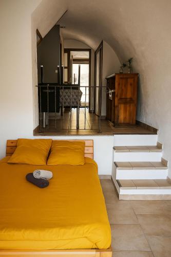 - une chambre avec un lit jaune et un escalier dans l'établissement sejour romantique entre mer et ciel, à Porri