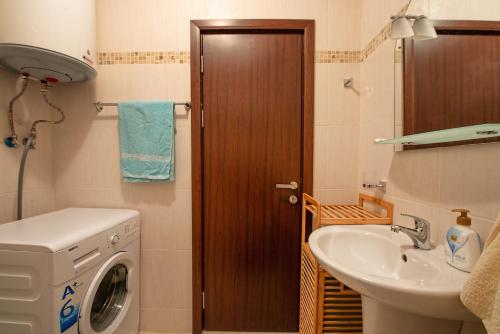 a bathroom with a washing machine and a sink at Cascadas Holiday Apartments in Sunny Beach