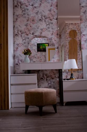 a room with a dresser and a chair and a lamp at Hotel Leoni in Kʼveda Sakʼara