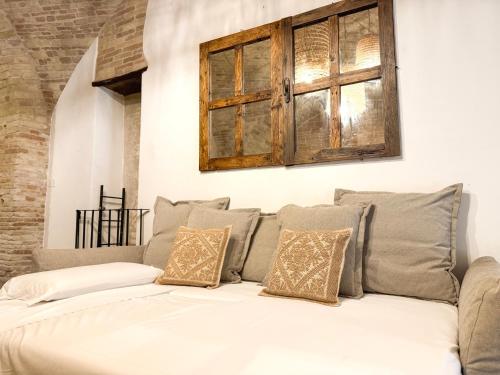 a white couch with pillows and a window at Kalma Arched Loft - Unique Brick Vault in City Heart in Cagliari