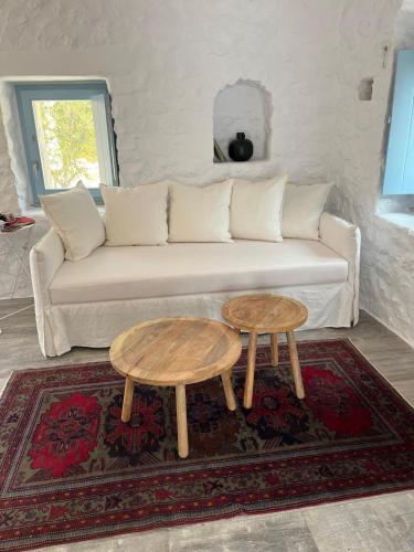 a living room with a couch and two tables at Σουίτα ΣΙΚΛΟΣ στο Καραβοστάσι Ν Οιτύλου Μάνης in Karavostasion