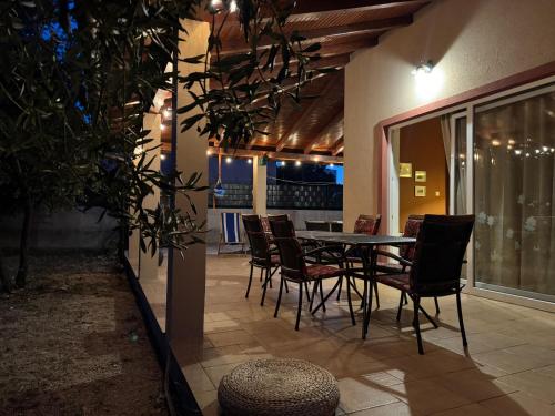 a dining table and chairs on a patio at night at Villa Tamaris hidden gem near beach in Jadrija