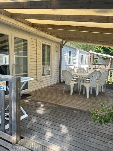 a patio with a table and chairs on a deck at Cozy bungalow in Ivry-la-Bataille