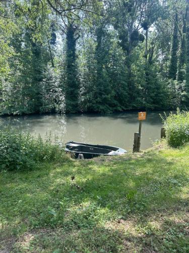 a boat sitting in the middle of a lake at Cozy bungalow in Ivry-la-Bataille