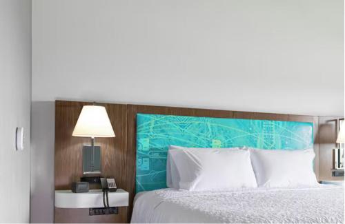 奥罗拉Hampton Inn Aurora Medical Center Denver的卧室里有一张带蓝色床头板的床