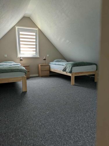 a bedroom with two beds and a window at Domek Letniskowy Zefirek in Nowy Dwór
