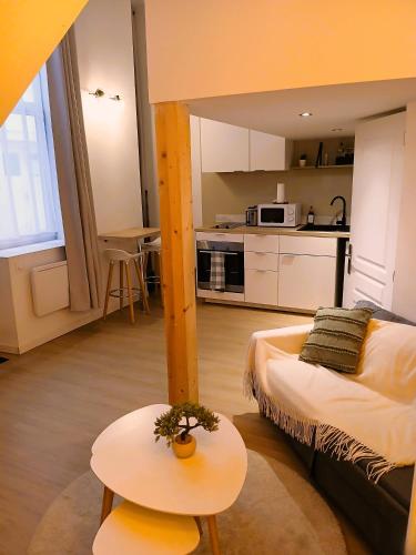 Cette chambre comprend un lit, une table et une cuisine. dans l'établissement studio en mezzanine, métro et rue centrale mais calme, à Oullins