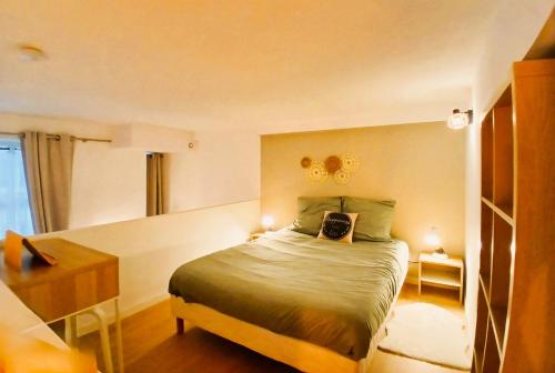 une petite chambre avec un lit et un bureau dans l'établissement studio en mezzanine, métro et rue centrale mais calme, à Oullins
