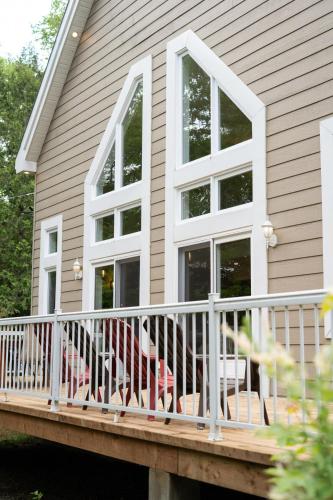 a porch with a white railing and a house at Le Havre d'Émélie dogfriendly Lake access in Sainte-Émélie-de-lʼÉnergie