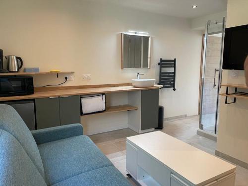 - un salon avec un canapé bleu et un lavabo dans l'établissement Chambre d'Hôtes Sablina, Parc et Plage des Minimes La Rochelle, à La Rochelle