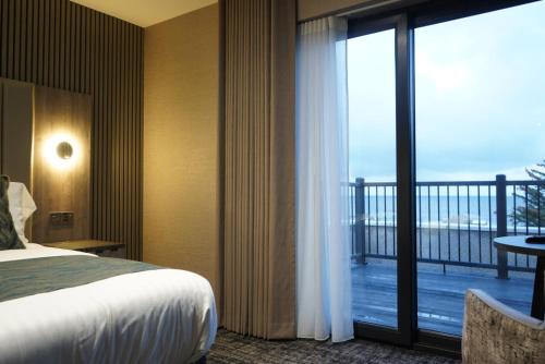 a hotel room with a bed and a balcony at The Knowes Hotel & Restaurant in Macduff