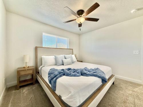 a bedroom with a bed with a ceiling fan at Townhome in Glendale UT near Zion with hot tub in Glendale