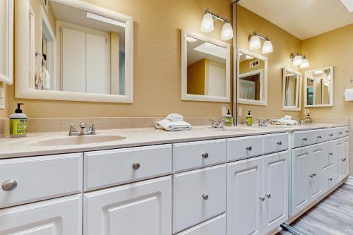 un baño con dos lavabos y dos espejos en North Beach B, en San Clemente