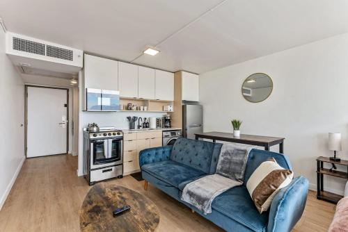 a living room with a blue couch and a table at High Rise 11th Floor City Views Free Pkg Gym in Salt Lake City