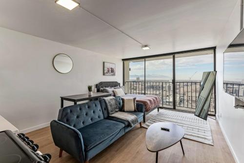 a living room with a couch and a large window at High Rise 11th Floor City Views Free Pkg Gym in Salt Lake City
