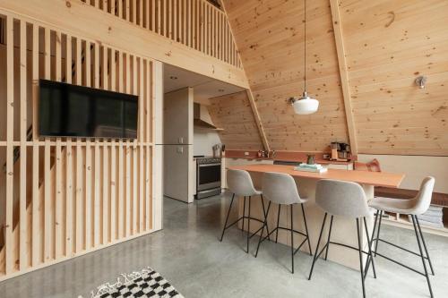 a kitchen with wooden walls and a bar with stools at Canadian Classic - Spa - Sauna - Fire - Forest in Val-David