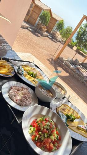 a table with many plates of food on it at villa mando camp in Nuweiba
