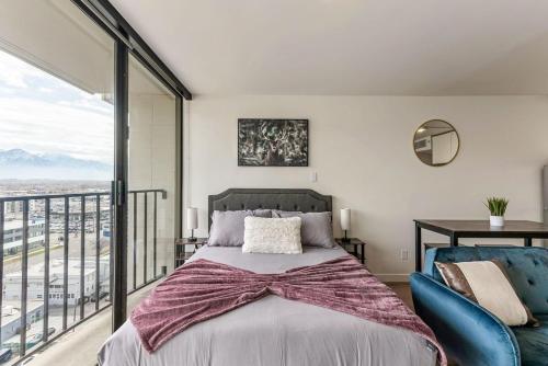 a bedroom with a large bed and a balcony at The White Mountain View Downtown Studio Apt Free Pkg Gym in Salt Lake City
