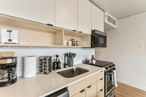 a kitchen with white cabinets and a sink at The White Mountain View Downtown Studio Apt Free Pkg Gym in Salt Lake City